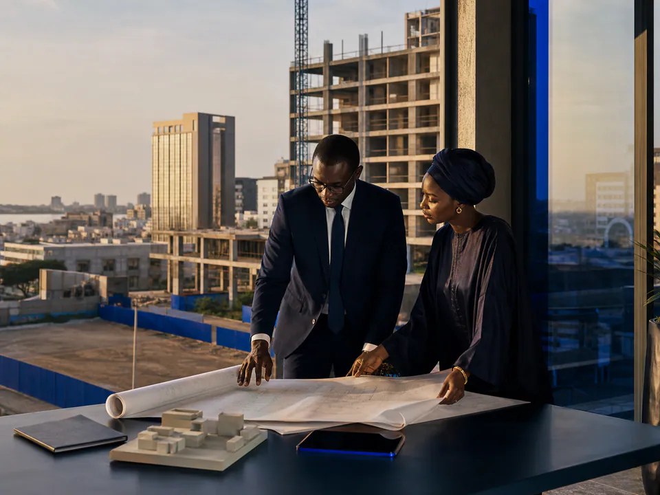 Illustration de professionnels étudiant les plans d’un projet immobilier fictif.